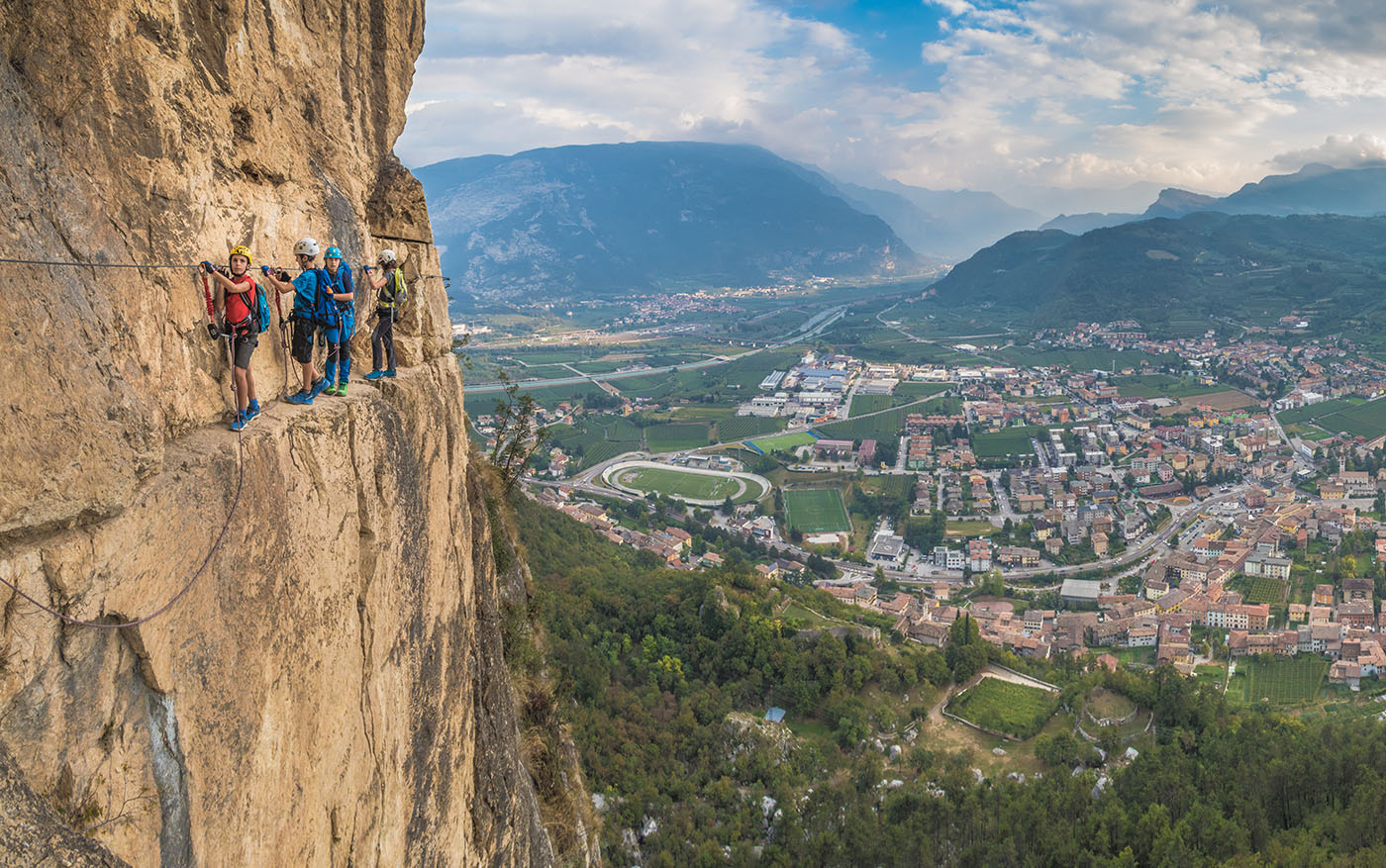 Climbers on a via ferrata route above the valley near Lake Garda